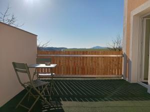 a table and chair on a balcony with a fence at Casa del Witzmann in Karlstein