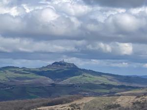 a hill with a lighthouse on top of it at Finestra sulla Val D'Orcia in Campiglia dʼOrcia