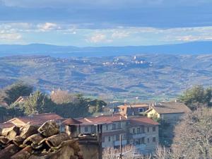 a building on top of a hill with mountains in the background at Finestra sulla Val D'Orcia in Campiglia dʼOrcia