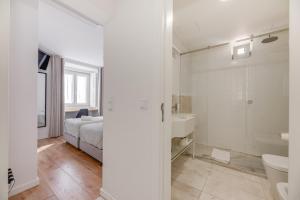 a bedroom with a bed and a bathroom with a shower at Correio Velho Hotel in Lisbon +58 photos