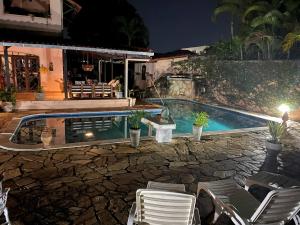 a swimming pool in front of a house at night at Taverna do Paraiso in Janga