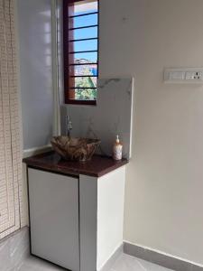 a bathroom counter with a sink and a window at R's Bolli Kudike in Madikeri