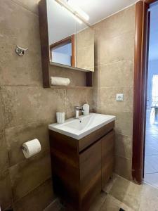 a bathroom with a sink and a mirror at GRILL&SEA apartments in Perea +25 photos