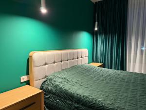 a bedroom with a bed and a green wall at GS Green Apartment in Starokostyantyniv