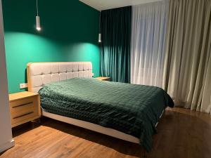 a bedroom with a bed and a green wall at GS Green Apartment in Starokostyantyniv +10 photos