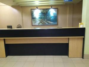 a reception desk in a lobby with a picture on the wall at Royal Park Residential Hotel in Chittagong