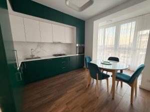 a kitchen with green cabinets and a table and chairs at GS Green Apartment in Starokostyantyniv