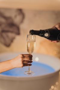 a person pouring a glass of wine at Golden Suite in Stornarella +21 photos