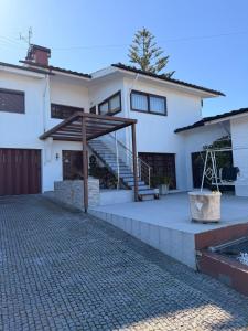 a large white house with a porch and stairs at Casa São Domingos 2 in Lousada