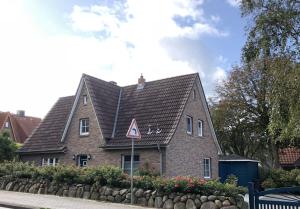 a brown brick house with a black roof at Ferienhaus Leegwater in Munkmarsch