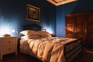 a bedroom with a bed with blue walls and a night stand at Casa Montefiori in Montefiore dellʼAso