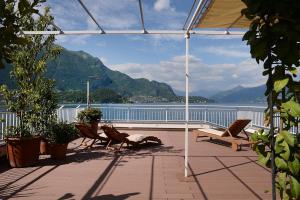 a balcony with chairs and a view of the water at Rhapsody on the Lake in Lezzeno