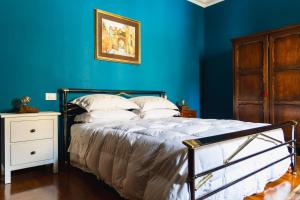 a bedroom with blue walls and a bed with white pillows at Casa Montefiori in Montefiore dellʼAso