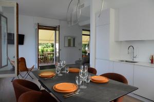 a dining room table with orange plates and glasses on it at Rhapsody on the Lake in Lezzeno +23 photos