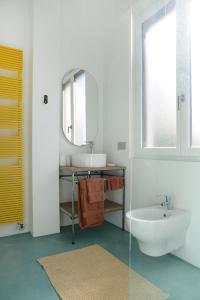 a white bathroom with a sink and a mirror at Rhapsody on the Lake in Lezzeno