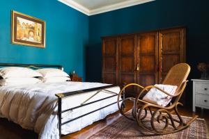 a bedroom with blue walls and a bed and a chair at Casa Montefiori in Montefiore dellʼAso