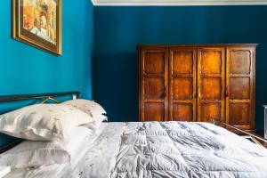 a blue bedroom with a bed and a wooden cabinet at Casa Montefiori in Montefiore dellʼAso