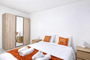 a white bedroom with a large bed with towels on it at Paris & Disney - 5 mins from Train Station - Champs Harmony in Champs-sur-Marne