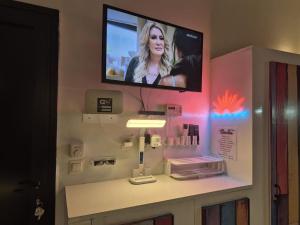 a bathroom with a tv on a wall at Studio Samba in Saly Portudal