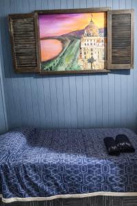 a painting on the wall above a bed in a room at Cabaña 3 del Puerto Gol in Santo Tomé