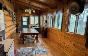 a dining room with a table in a log cabin at Katherine Lake Lodge in Hazelhurst