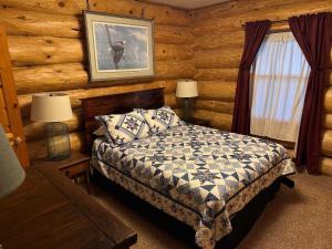 a bedroom with a bed in a log cabin at Katherine Lake Lodge in Hazelhurst