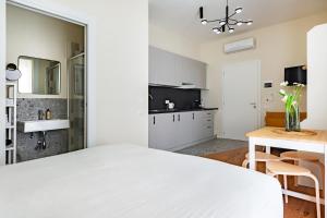 a bedroom with a white bed and a kitchen at Piccinni 133 in Bari +13 photos