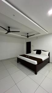 a bedroom with a bed with a ceiling fan at Gravity Groups Golden Residency in Puducherry Airpoert