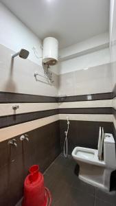 a bathroom with a toilet and a red fire hydrant at Gravity Groups Golden Residency in Puducherry Airpoert