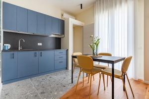 a kitchen with blue cabinets and a table and chairs at Piccinni 133 in Bari