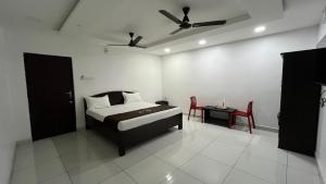 a bedroom with a bed and a table and chairs at Gravity Groups Golden Residency in Puducherry Airpoert