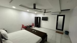 a bedroom with a bed and a table and a mirror at Gravity Groups Golden Residency in Puducherry Airpoert