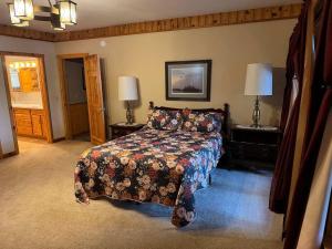 a bedroom with a bed and two lamps on tables at Katherine Lake Lodge in Hazelhurst