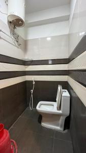a bathroom with a white toilet in a room at Gravity Groups Golden Residency in Puducherry Airpoert +3 photos