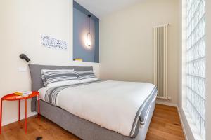 a small bedroom with a bed and a red table at Piccinni 133 in Bari