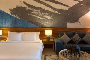 a hotel room with a bed and a couch at Mantra Samui Resort - Adults Only in Mae Nam