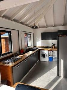 a kitchen with a stove and a sink in it at Location saisonnière in Petit-Bourg