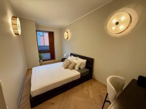 a bedroom with a bed with white sheets and a window at Vallikraavi Old Town Apartment in Tartu