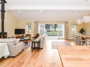 a living room with a couch and a table at Beaufort Dairy in Pulborough
