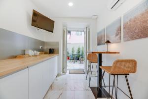 a kitchen with a bar and stools in a room at Correio Velho Hotel in Lisbon