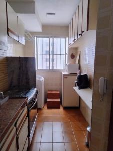 a small kitchen with a stove and a window at Apartamento 3 quarto Alto Bueno in Goiânia