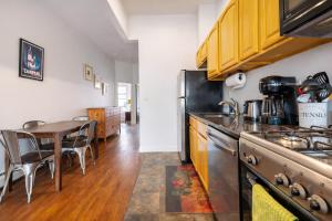 a kitchen with a stove and a dining table at Plush & Spacious 2-Bedroom in NYC in New York +7 photos