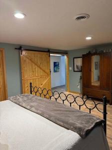 a bedroom with a large bed with a wooden door at Brandy Bay Hideaway: Pet Friendly Retreat in Arbor Vitae