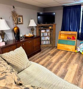 a living room with a television and a wooden floor at Brandy Bay Hideaway: Pet Friendly Retreat in Arbor Vitae +40 photos