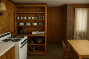 a kitchen with a white stove and a table at Gresham Shores - Lil' Sunfish - PET FRIENDLY in Arbor Vitae