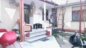 a front porch of a house with a red chair at Stairway to heaven in Shkodër