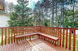 a wooden bench on a wooden deck with trees at Lilly Pad Landing in Hazelhurst