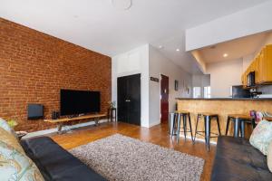 a living room with a couch and a brick wall at Plush & Spacious 2-Bedroom in NYC in New York