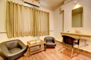 ein Wartezimmer mit zwei Stühlen und einem Schreibtisch in der Unterkunft MY Bizz Hotel Sapna in Pune