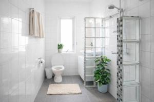 a white bathroom with a toilet and a shower at HaHa Gothenburg City Apt for 2 in Gothenburg